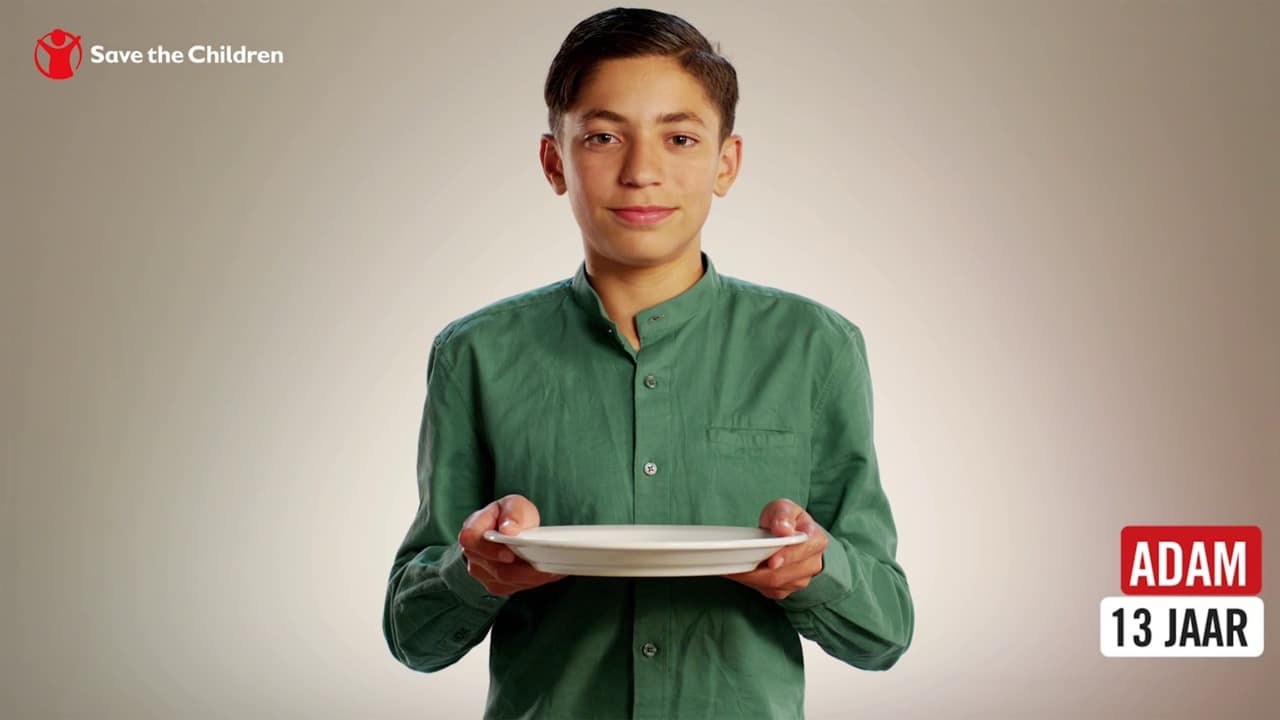 Frontaal profielbeeld van een jongen die een bord vasthoudt voor een Save the Children-commercial